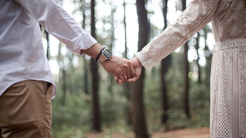 Hình ảnh hai vợ chồng nắm tay tình cảm ở đồi thông