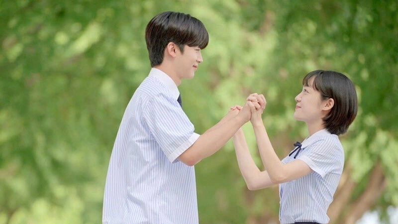 Đập tay nhau vui vẻ trên sân trường trong đồng phục học sinh