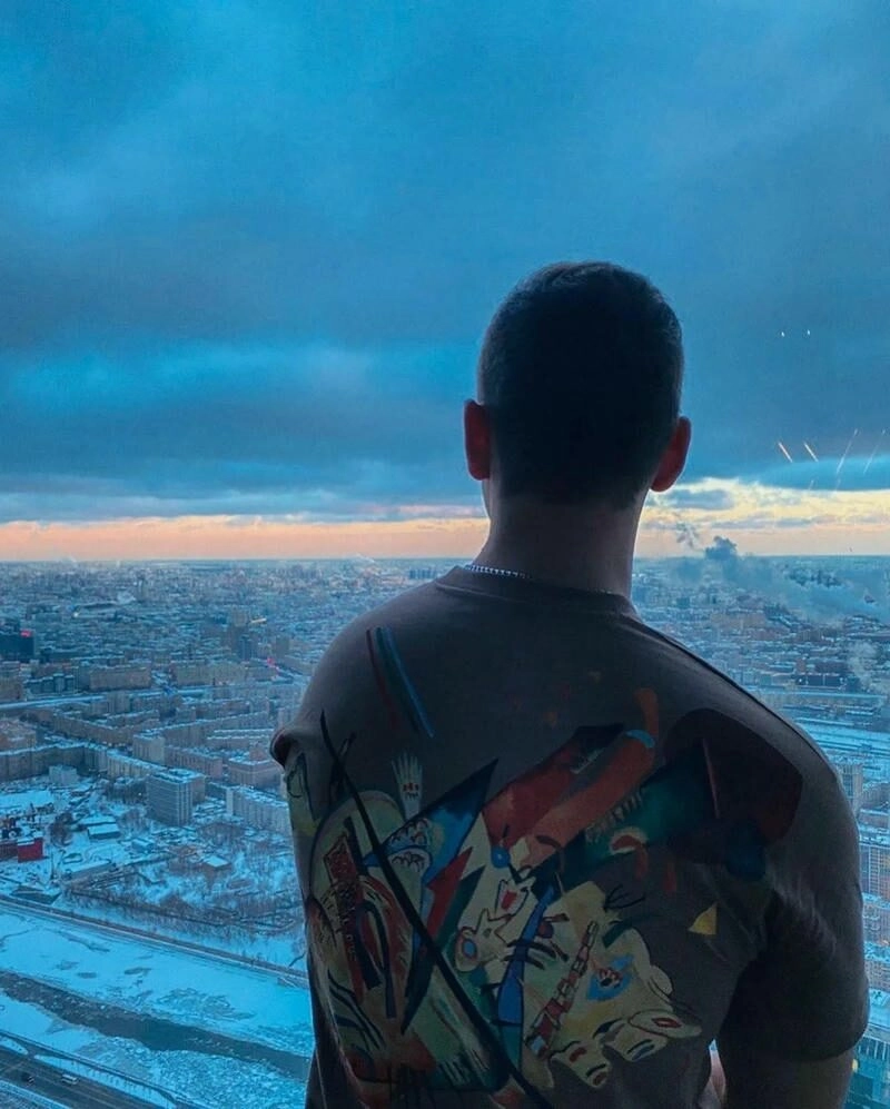 Trai đẹp che mặt quay lưng trong không gian ngoài trời thoáng đãng